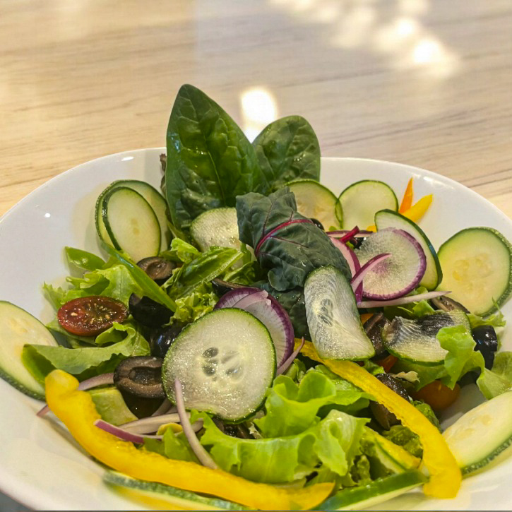 "Ensalada verde fresca con aguacate, pepino y espinacas."