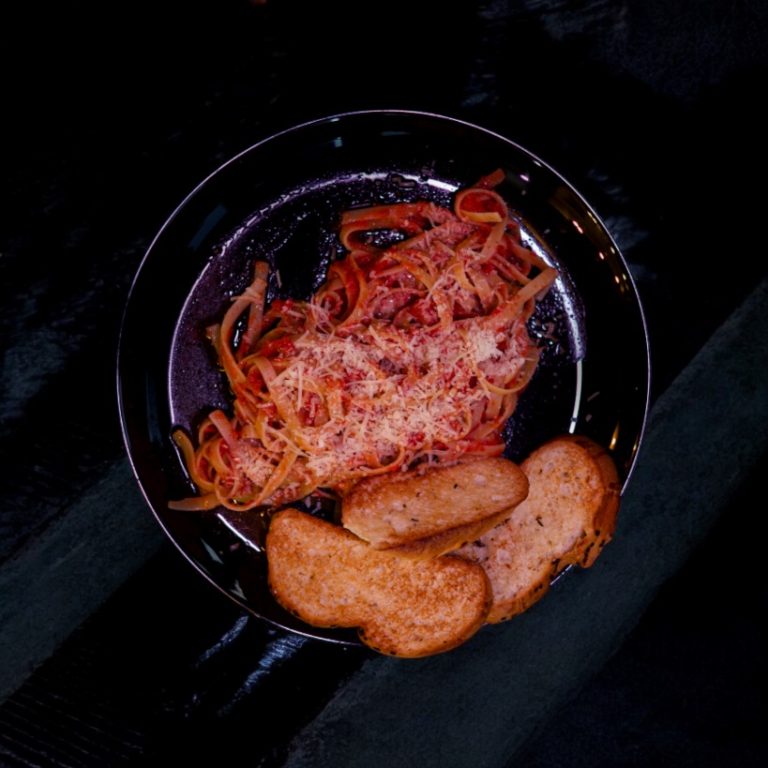 "Pasta arrabbiata con salsa de tomate picante y albahaca fresca."
