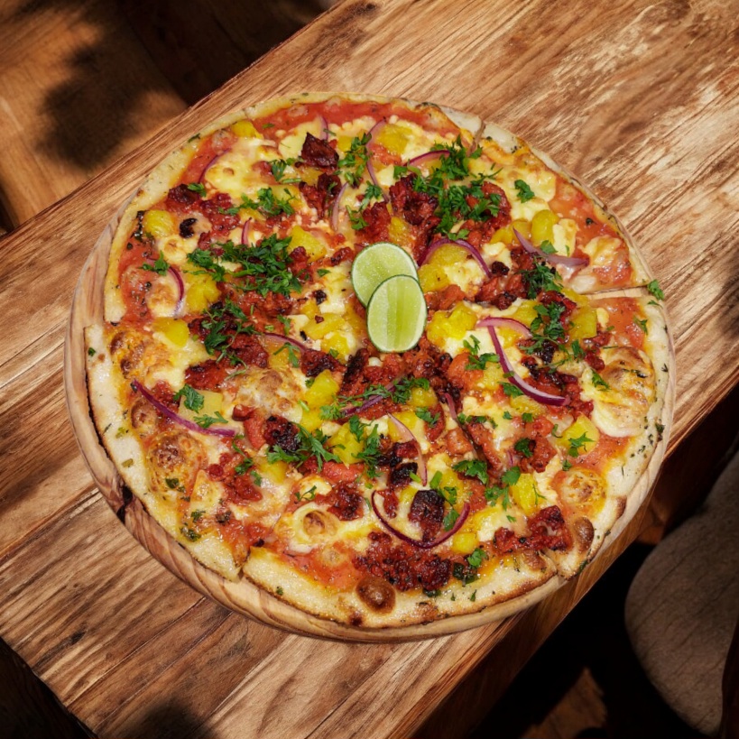 "Pizza al pastor con piña, cebolla y cilantro."