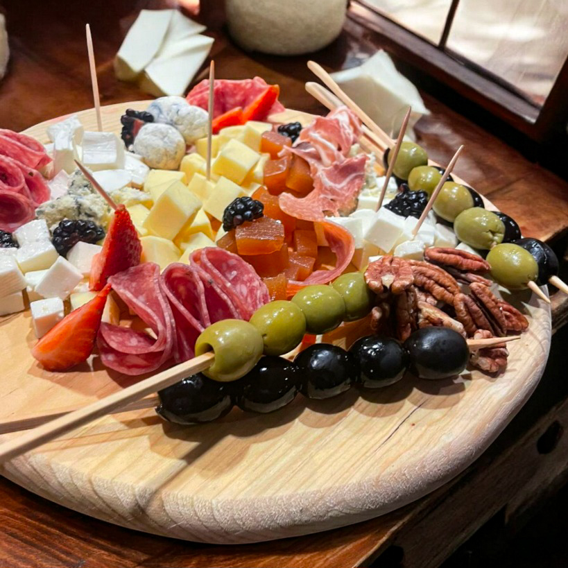 "Tabla de quesos variados con frutas y nueces."