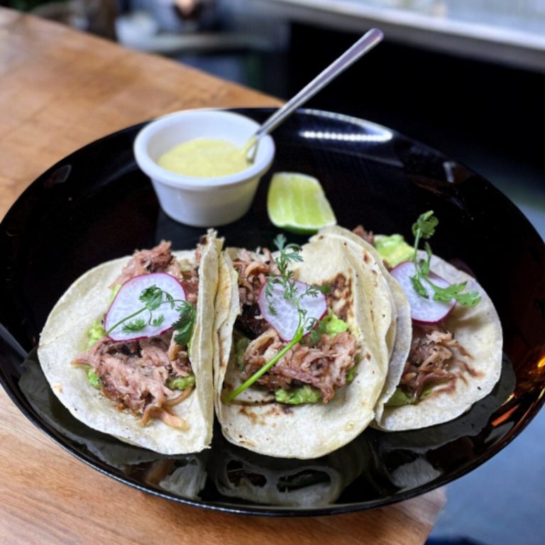"Tacos de chamorro con cebolla, cilantro y salsa verde."